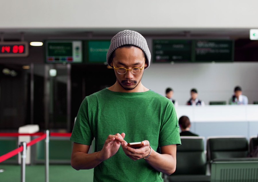 man wearing a beanie with a smartphone in his hands