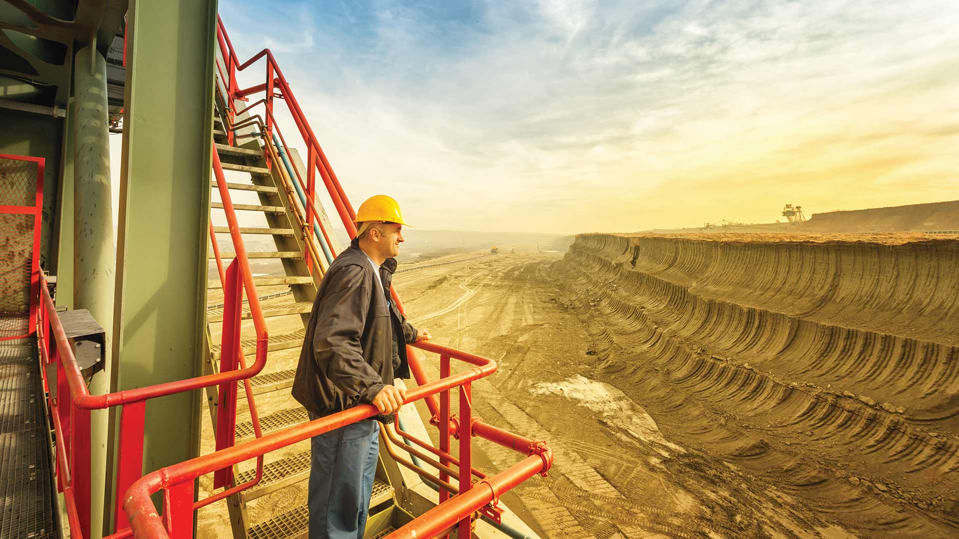 a worker standing on a drill machine at mines