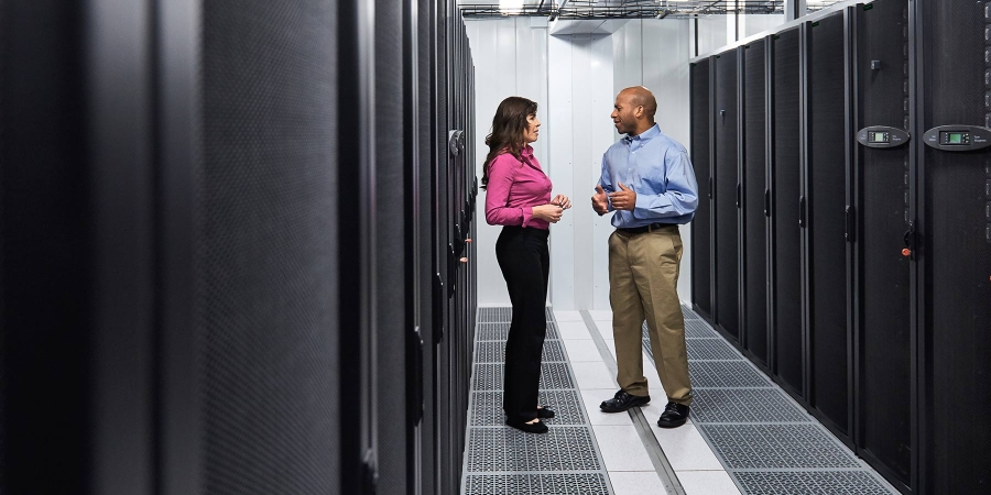 two business persons talking while standing at the data center