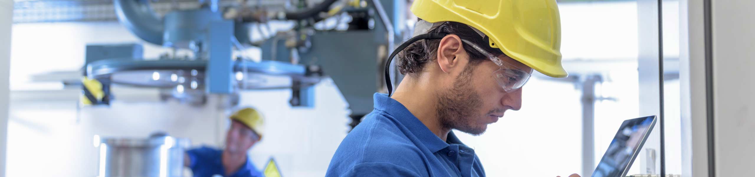 Workers operating environmental testing equipment with digital tablet in electronics factory