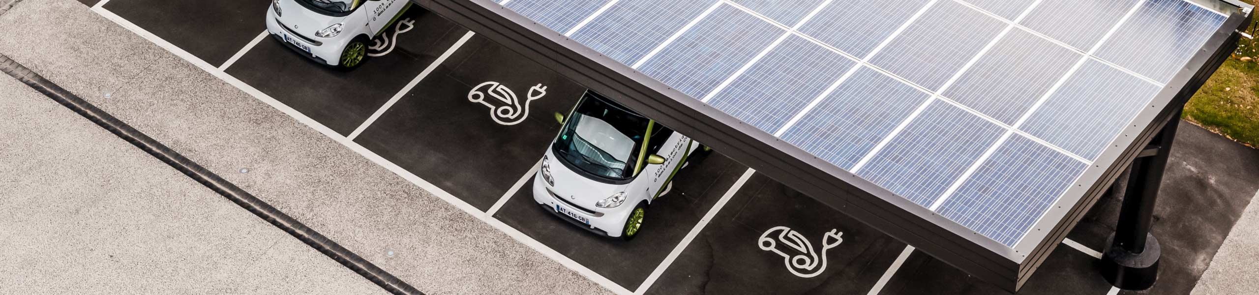 Electric vehicles charging in a solar car port.