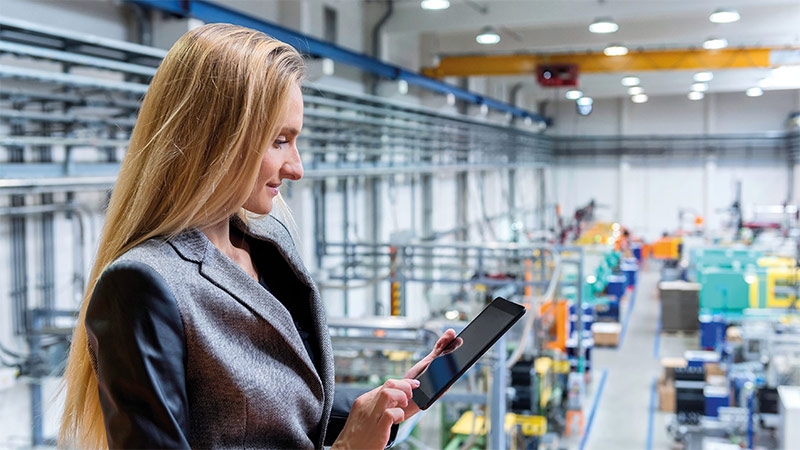 long haired woman clipboard looking into warehouse