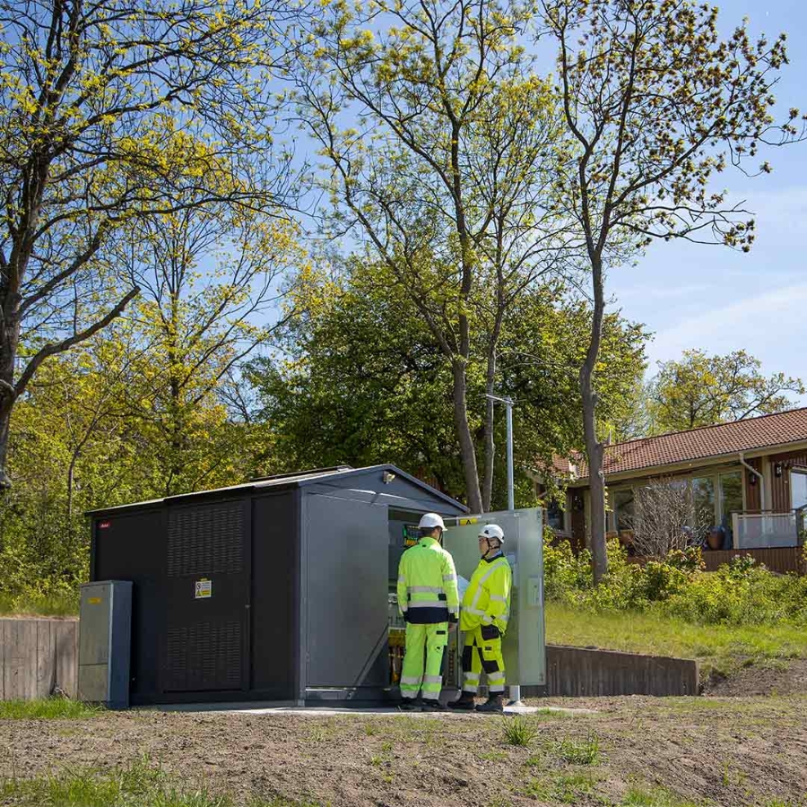 A group of men wearing safety gear standing outside a shed