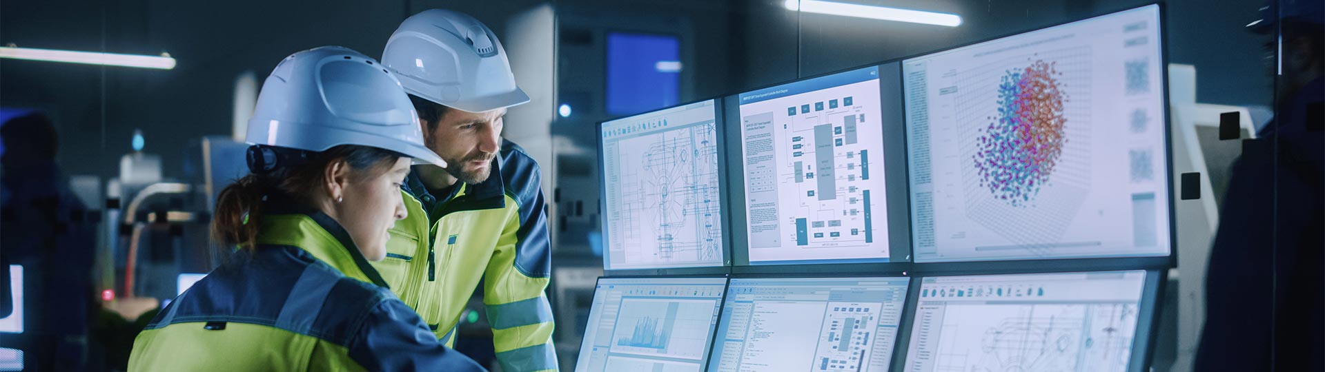 A person in a hard hat looking at a computer screen