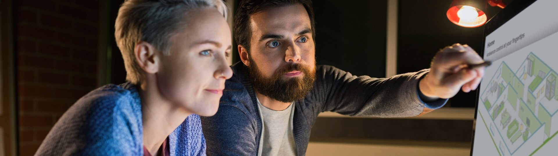 Two people are looking at the product on the screen