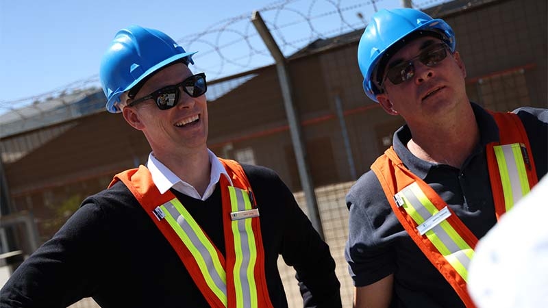 A couple of men wearing safety vests and blue helmets