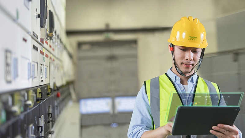 A man holding a computer in a factory